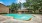 Large sparkling blue pool with a large pool deck and lounge chairs