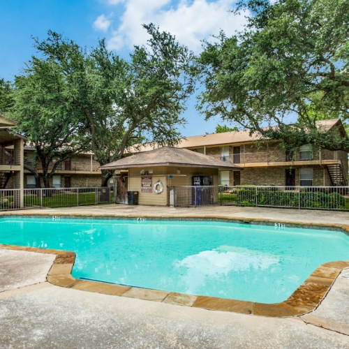 Large sparkling blue pool with a large pool deck and lounge chairs